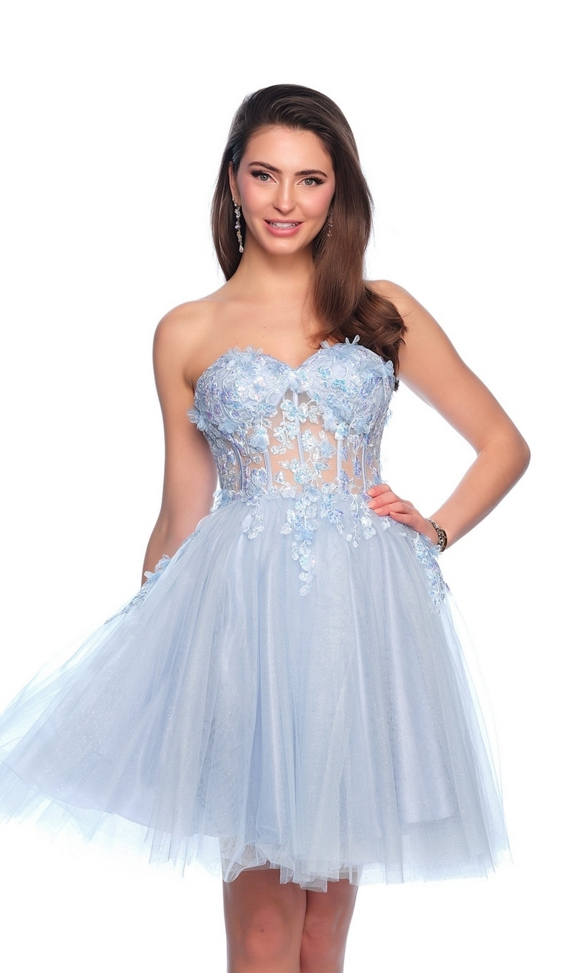Woman wearing the Sheer Glitter Homecoming Dress 11973—a strapless, light blue, knee-length dress with floral embroidery, appliqué details, and a tulle skirt—standing against a white background.